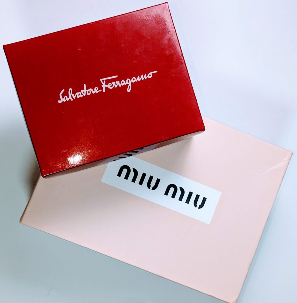 Red Ferragamo and pink Miu Miu handbag boxes.